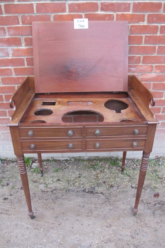 A George III mahogany gentleman's washstand with a lift up lid over dummy drawers and turned legs