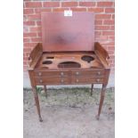 A George III mahogany gentleman's washstand with a lift up lid over dummy drawers and turned legs