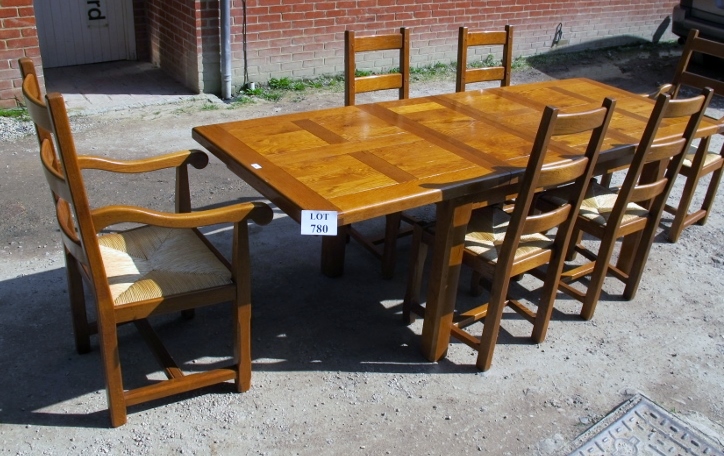 A late 20c pale oak dining table with six matching chairs all with rush seats and to include two