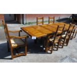 A late 20c pale oak dining table with six matching chairs all with rush seats and to include two