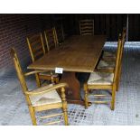 A 20c oak refectory dining table and eight oak ladder back chairs with rush seats and in good