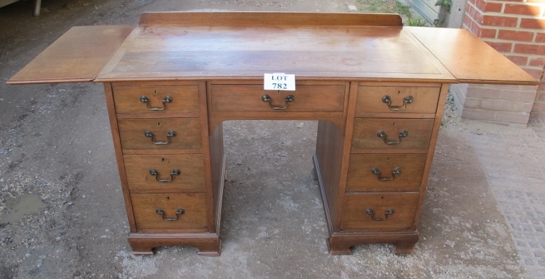 A c1900 oak/walnut writing desk with end drop leaves and nine drawers est: £200-£400