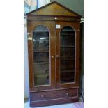 A Victorian mahogany glazed bookcase with arched doors over a long drawer and five shelves inside