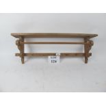 A pine hanging shelf with towel rail and