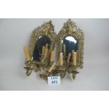 A pair of gilded wall mirrors with candl