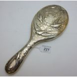 A silver hand mirror embossed with flyin
