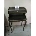 A small black and gilt painted tiered si
