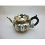 A silver teapot with embossed decorative