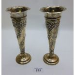 A pair of silver vases embossed with flo