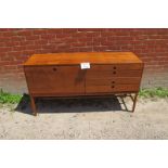 A 1970's Danish teak sideboard with fall front cupboard door and fitted cutlery drawer over three