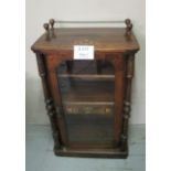 A Victorian rosewood inlaid music cabinet with glazed central door flanked either side by turned