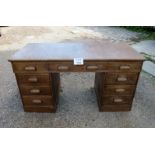 An early 20c solid oak pedestal desk with three drawers to top over three further drawers to each