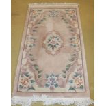 A 20c Chinese wool rug on pale salmon gr