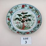 An 18c Chinese charger with hand painted tree to centre and flower and leaf border no marks to base