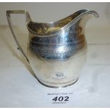 A Georgian silver cream jug with engrave