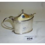 A silver mustard pot with blue liner Lon