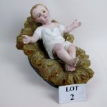 A vintage plaster model of the baby Christ in his crib,