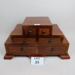 A reproduction mahogany apprentice chest of stepped design, six graduated drawers,