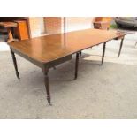 A Regency mahogany dining table complete with three additional leaves and terminating on reeded