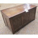 An 18th century oak coffer with carved panels to front and sides beneath a three plank top est: