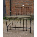 A Victorian wrought iron black bed frame with highlights,