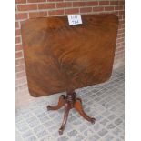 A Regency flame mahogany square tilt top table with reeded edge over a turned column and cabriole