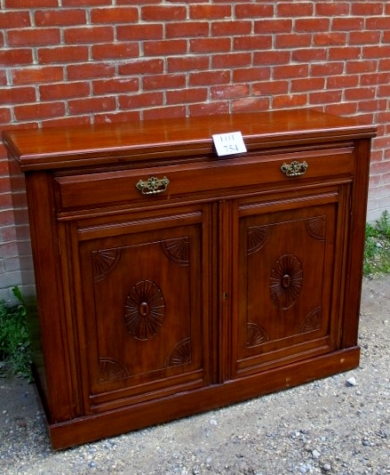 A 19th century mahogany sideboard with single drawer over cupboard doors with carved panels clean