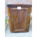 A Georgian oak country corner cupboard with shaped shelves and a panelled door (evidence of old