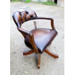 A mahogany framed Captain's swivel desk chair upholstered in brown leather (adjustable height and