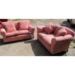 A pair of Edwardian two seater sofas upholstered in pink floral material est: £100-£200