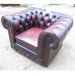 A late 20th century deep buttoned red leather Chesterfield armchair (complete with Fire Regs label