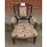 A small Victorian mahogany armchair with carved back splat and upholstered in floral material