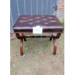 A mahogany X frame stool upholstered in buttoned brown leather with turned stretcher and reeded