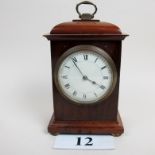 An Edwardian mahogany mantel clock with boxwood stringing, brass carrying handle, brass bun feet,