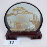 An intricately carved Chinese cork Diorama, contained within a lacquered frame and stand,