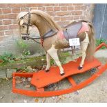 A 19th century hide covered rocking horse with leather saddle and mounted on a platform base with