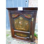 A 19th century oak corner cupboard with hand painted panelled door and two shaped shelves to