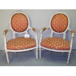A pair of late 19th century French white painted armchairs upholstered in red and gilt floral