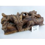 A modern Chinese carved wooden ornament depicting a coiled dragon with puzzle ball,