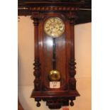 A 19th century continental glazed walnut cased Vienna-type wall clock, with pendulum,