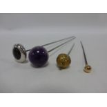 Four early 20thC hat pins, the two longest with purple stone finials,