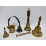 Four assorted bells inc two with turned wooden handles and a brass mortar & pestle.