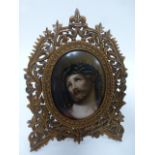 An oval printed picture of Jesus Christ within an intricately carved floral and foliate fruitwood