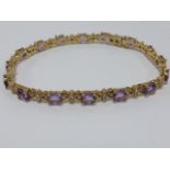 9ct gold tennis bracelet set with Amethysts and Diamond chips, 7" in length, 10.5g.
