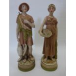 Pair of early 20th Century Royal Dux classical robed figures of Huntsman and Fisherwoman 32cm high.