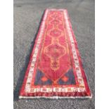 A Persian long hall runner carpet with four medallions in central lozenge,