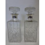 Pair of silver collared cut glass decanters, hallmarked London 1964, 25cms in height.