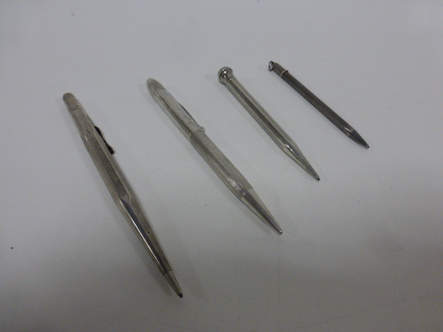 Four silver propelling pencils.