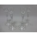 Two pairs of 22cm clear glass candle holders on broad circular bases.