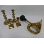 Brass car horn and two pairs of candlesticks with pushers.